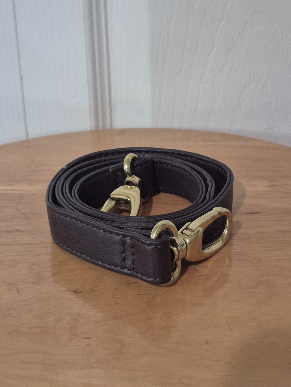 Brown leather purse strap with brass toned hardware